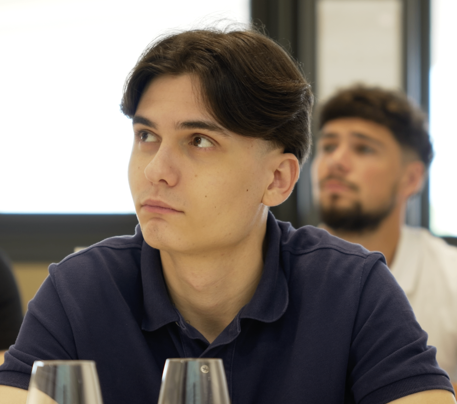 Jeune membre en polo marine attentif pendant la masterclass