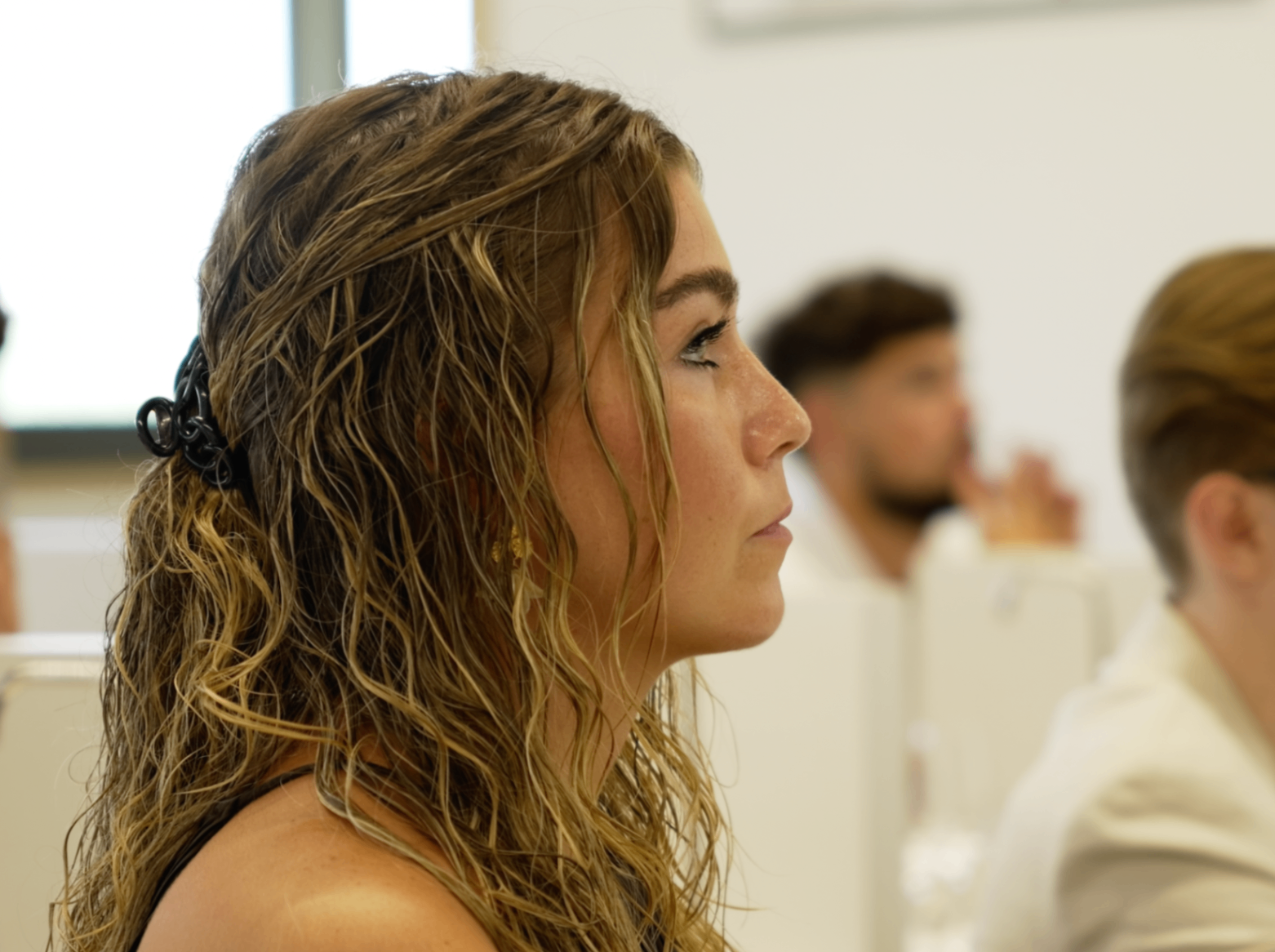 Membre aux cheveux bouclés attentive de profil pendant la présentation