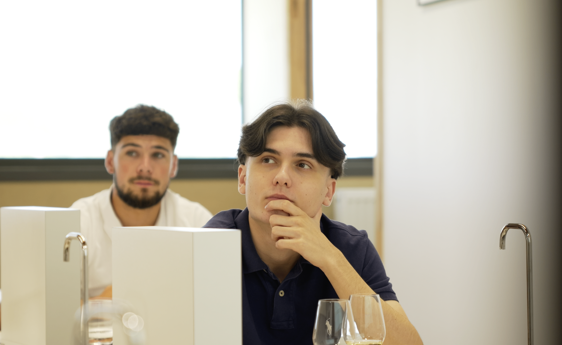 Jeune membre en polo marine en pleine réflexion pendant la session