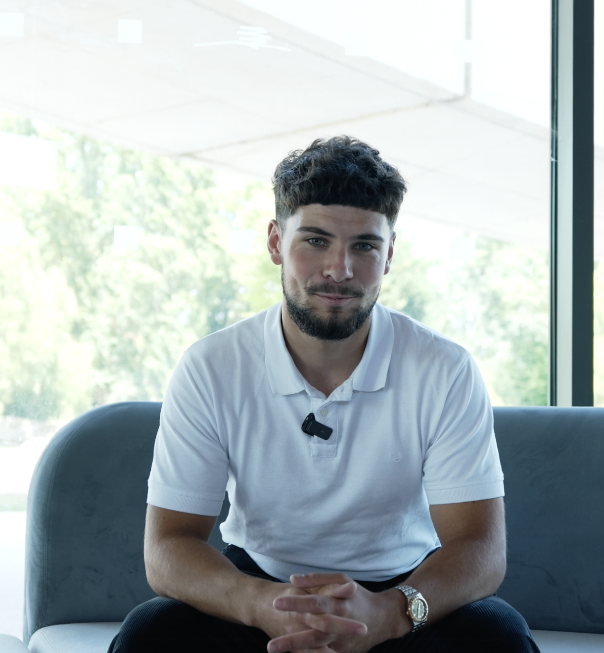 Portrait d'un membre en polo blanc sur canapé