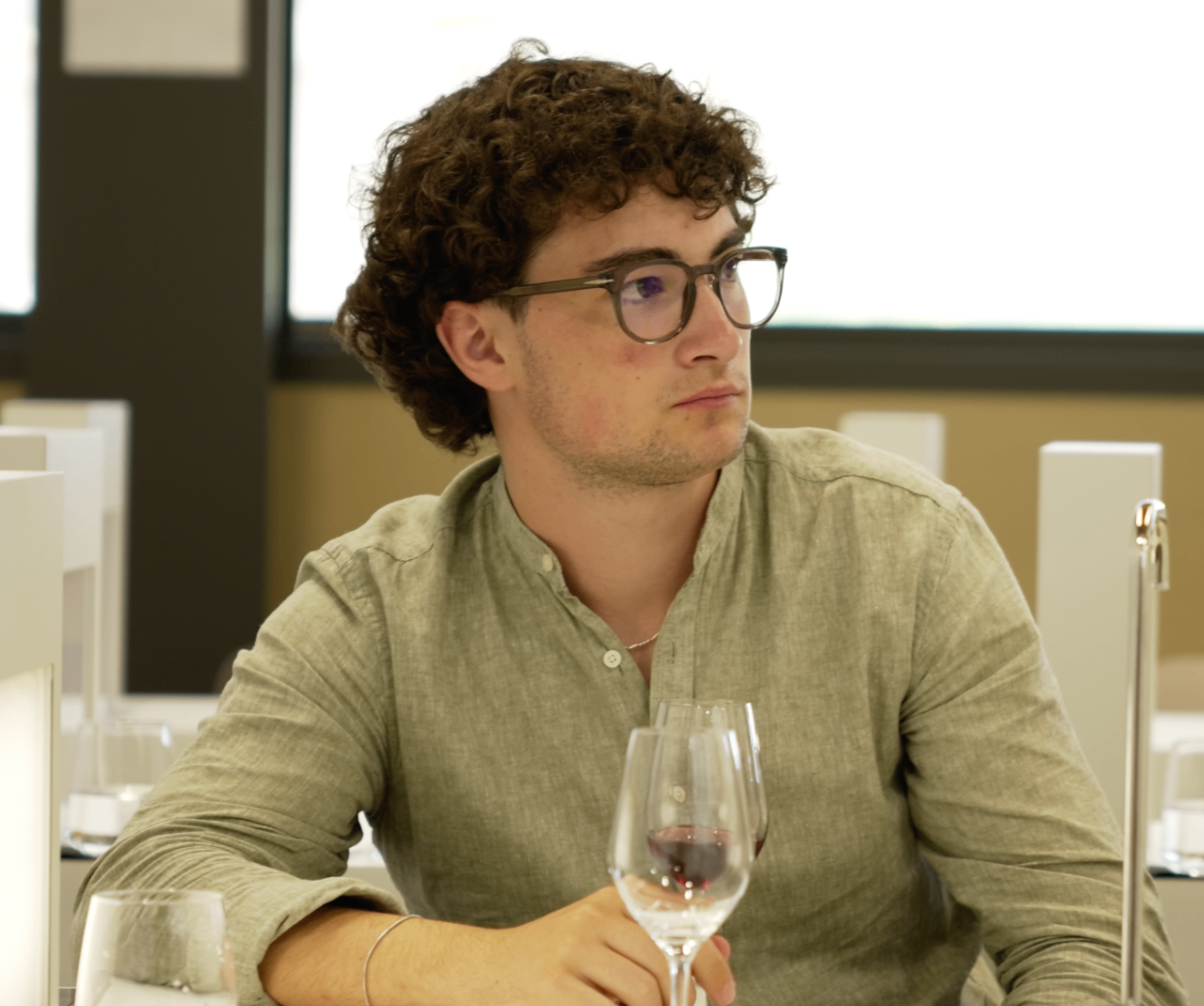 Membre en chemise de lin assis avec un verre pendant la masterclass