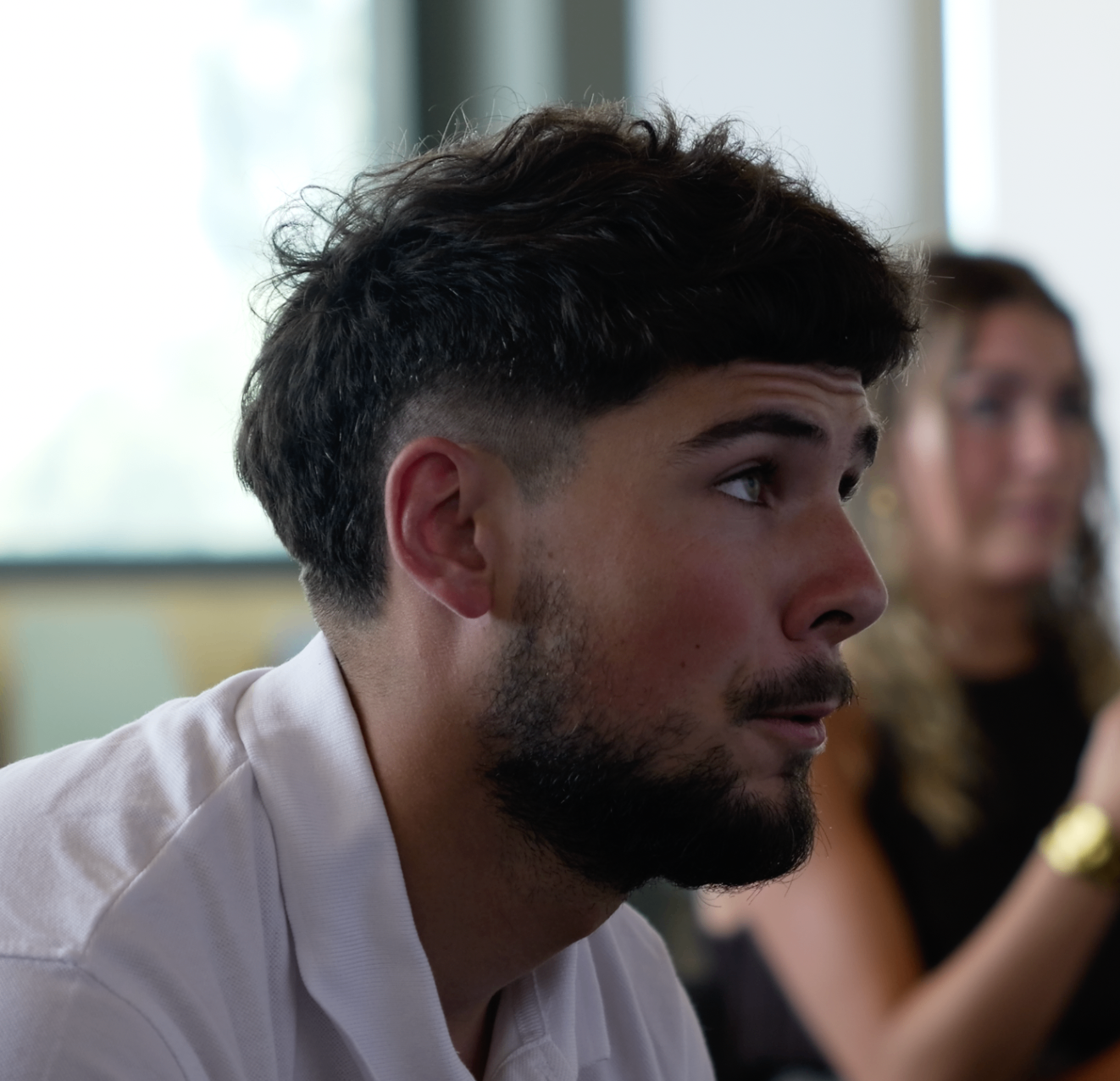 Portrait rapproché d'un membre barbu en polo blanc