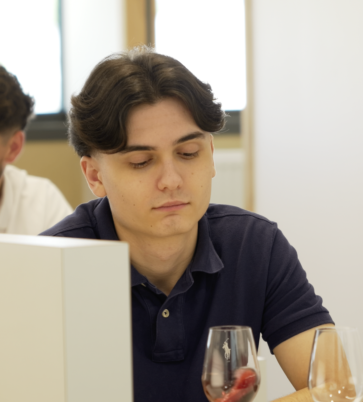 Jeune membre en polo marine concentré pendant la dégustation