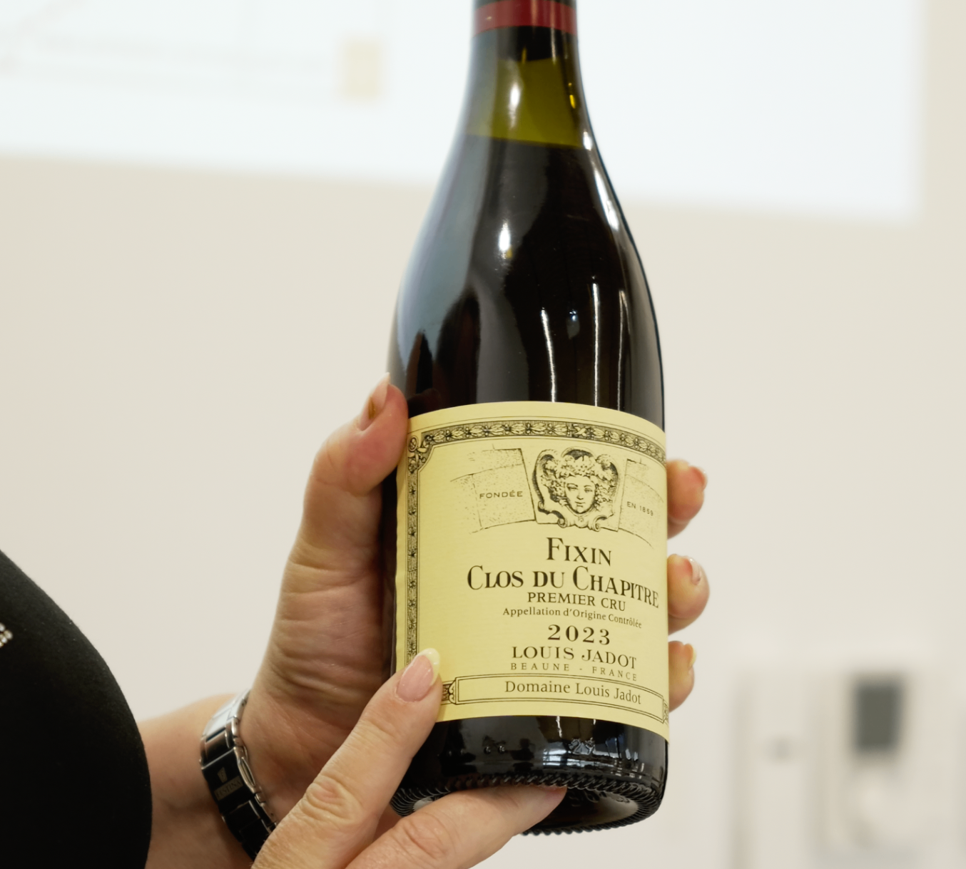 Bouteille de Fixin Clos du Chapitre Premier Cru tenue en main